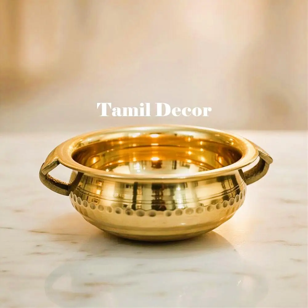 Traditional brass urli bowl with side handles used for home decor and festive decoration