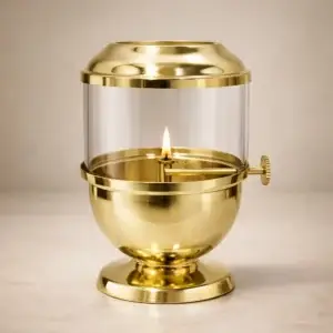 Traditional brass oil lamp with glass cover used for pooja rituals