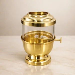 Traditional brass oil lamp with glass cover used for pooja rituals